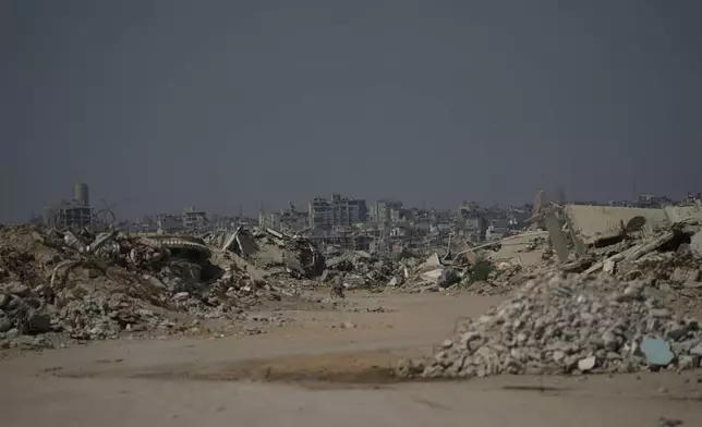A Palestinian man rides his bicycle by the rubble of buildings that were destroyed during the Israel Hamas war, in Khan Younis, southern Gaza Strip, Friday, July 31, 2026. (AP Photo/Abdel Kareem Hana)