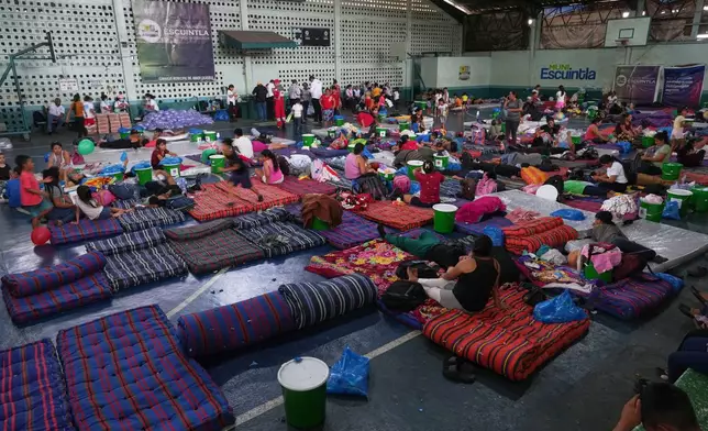 Residents evacuated from El Porvenir, a village on the slopes of the Fuego volcano, gather in a temporary shelter in Escuintla, Guatemala, Tuesday, Aug. 4, 2026. (AP Photo/Moises Castillo)