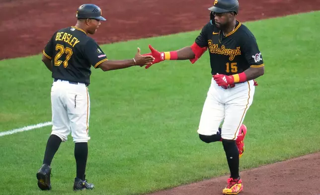 Pittsburgh Pirates' Oneil Cruz (15) is greeted by third base coach Tony Beasley (27) as he rounds third after hitting a two-run home run off Detroit Tigers pitcher Keider Montero during the fifth inning of a baseball game in Pittsburgh, Tuesday, Aug. 18, 2026. (AP Photo/Gene J. Puskar)