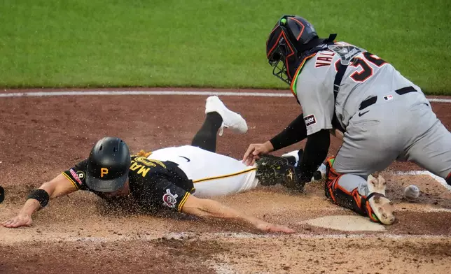 Pittsburgh Pirates' Jake Mangum, left, is ruled out when he can't reach home plate as he slides around Detroit Tigers catcher Eduardo Valencia, who drops the ball on the play, during the fifth inning of a baseball game in Pittsburgh, Tuesday, Aug. 18, 2026. (AP Photo/Gene J. Puskar)