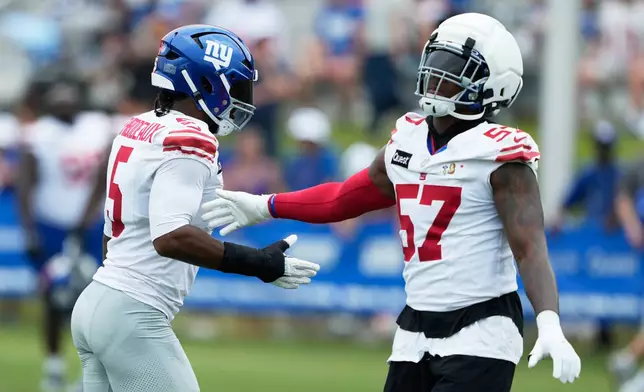 New York Giants' Chauncey Golston greets Kayvon Thibodeaux at practice during an NFL football training camp, Saturday, Aug. 1, 2026, in White Sulphur Springs, W.Va. (AP Photo/Chris Carlson)