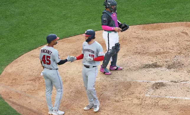 Washington Nationals' Brady House, right, high-fives Andrew Pinckney (45) after his home run during the sixth inning of a baseball game against the New York Mets, Saturday, Aug. 15, 2026, in New York. (AP Photo/Heather Khalifa)