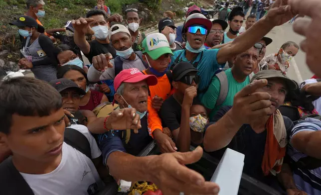 FILE - People reach out to receive supplies from volunteers, days after an earthquake struck La Guaira, Venezuela, June 30, 2026. (AP Photo/Matias Delacroix, File)