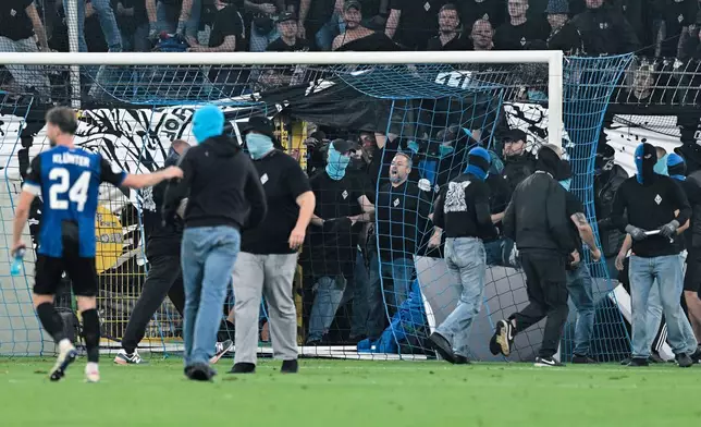 SV Mannheim supporters storm the field during the Germany Cup soccer match between SV Waldhof Mannheim and 1. FC Kaiserslautern, Friday, Aug. 21, 2026, in Mannheim, Germany. (Uwe Anspach/dpa via AP)