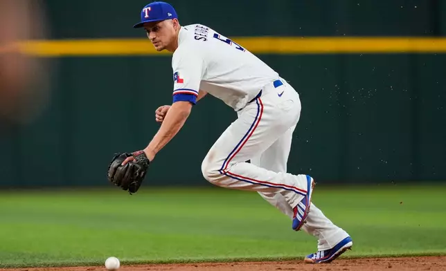 Texas Rangers shortstop Corey Seager is unable to reach a single by Washington Nationals' Jacob Young in the second inning of a baseball game Wednesday, Aug. 19, 2026, in Arlington, Texas. (AP Photo/Tony Gutierrez)