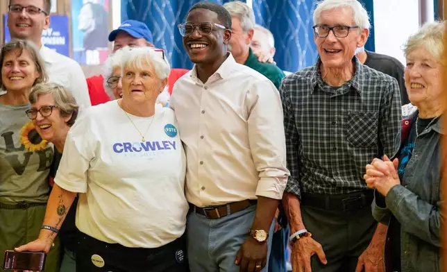 David Crowley, Democratic candidate for Wisconsin governor, center, takes a group photo with Wisconsin Gov. Tony Evers, right, and supporters gathered at the Sheboygan County Democratic Party office during a campaign stop Friday, Aug. 7, 2026, in Sheboygan, Wis. (AP Photo/Kayla Wolf)