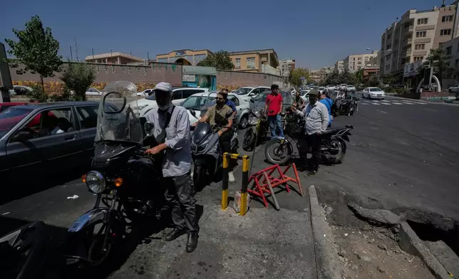 Motorcycles and cars line up outside a gas station in Tehran, Iran, Tuesday, Aug. 25, 2026. (AP Photo/Vahid Salemi)