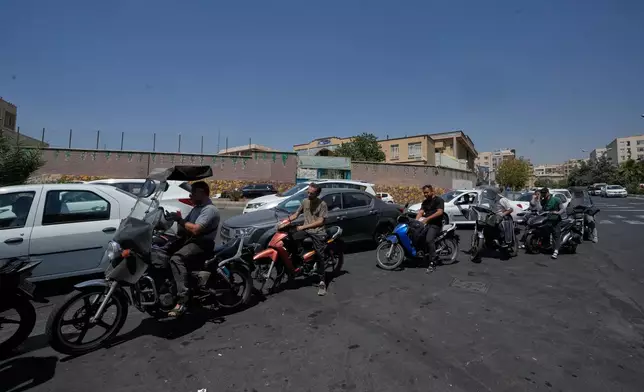 Motorcycles and cars line up outside a gas station in Tehran, Iran, Tuesday, Aug. 25, 2026. (AP Photo/Vahid Salemi)