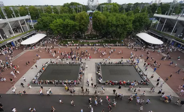 Spectators walk around the grounds of the USTA Billie Jean King National Tennis Center during the first round of the U.S. Open tennis championships Sunday, Aug. 30, 2026, in New York. (AP Photo/Frank Franklin II)