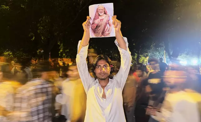 FILE- A protestor holds a placard with a portrait of Indian Prime Minister Narendra Modi draped in a saree, a traditional garment for women in India, during a demonstration demanding educational reforms as part of the Cockroach Janta Party's ongoing protest movement in New Delhi, India, Thursday, July 23, 2026. (AP Photo/Verda Subzwari, File)