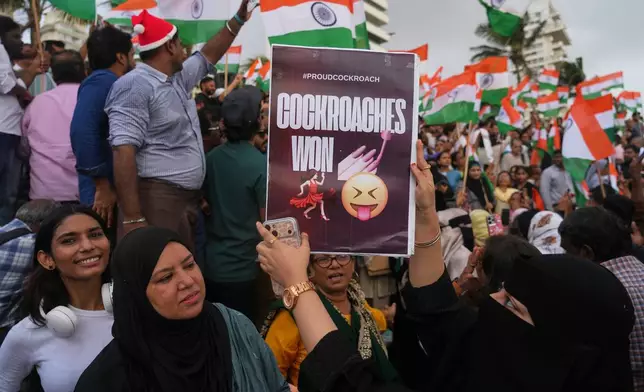 FILE- A protester holds a placard after India's Education Minister Dharmendra Pradhan resigned following nationwide protests as part of the Cockroach Janta Party's protest movement in Mumbai, India, Saturday, July 25, 2026 (AP Photo/Rafiq Maqbool, File)