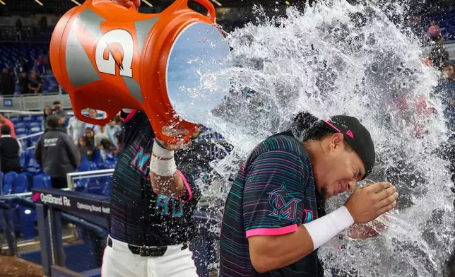 Miami Marlins' Javier Sanoja gets doused with a water cooler by teammate Joe Mack after hitting a game-winning RBI single during the ninth inning of a baseball game against the Washington Nationals, Friday, Aug. 21, 2026, in Miami. (AP Photo/David Santiago)