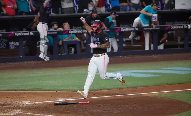 Miami Marlins designated hitter Agustín Ramírez (50) scores on a game-winning RBI single by Javier Sanoja during the ninth inning of a baseball game against the Washington Nationals, Friday, Aug. 21, 2026, in Miami. (AP Photo/David Santiago)