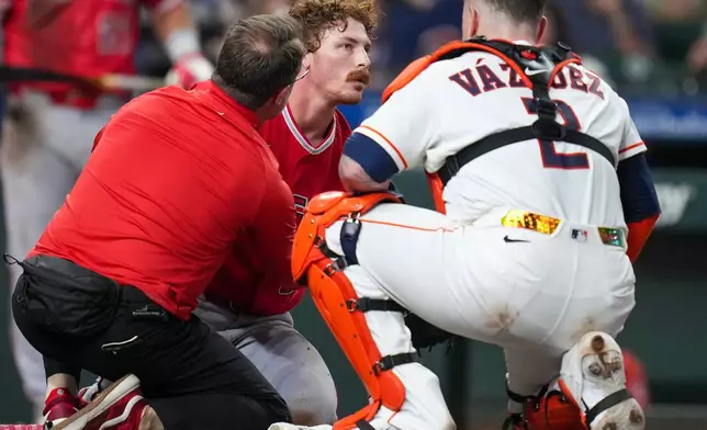 Los Angeles Angels' Wade Meckler, center, is looked at by a trainer, left, and Houston Astros catcher Christian Vázquez (2) after being hit in the head by a pitch during the fifth inning of a baseball game Thursday, Aug. 20, 2026, in Houston. (AP Photo/Eric Christian Smith)