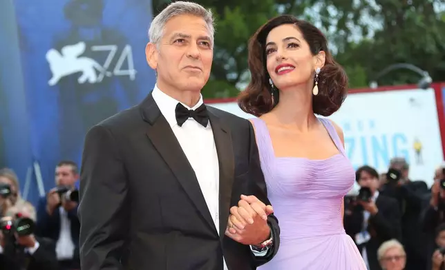 FILE - George Clooney, left, and Amal Clooney appear at the 74th edition of the Venice Film Festival in Venice, Italy, on Sept. 2, 2017. (Photo by Joel Ryan/Invision/AP, File)