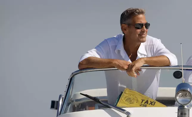 FILE - George Clooney arrives in Venice, Italy on a taxi boat for the 65th Venice Film Festival on Aug. 26, 2008. (AP Photo/Joel Ryan, File)
