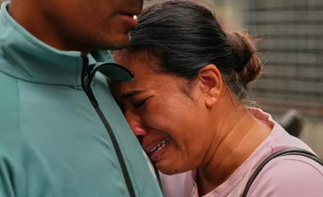 A relative consoles Sabina Dangal outside a government hospital as she waits for news of her brother, who is missing after flash floods, in Kathmandu, Nepal, Friday, Aug. 28, 2026. (AP Photo/Dar Yasin)