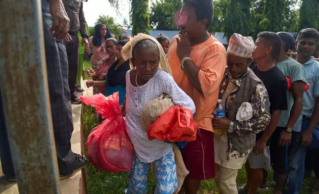 Kanchi Nepali, a survivor of flash floods, receives relief supplies in the Devighat area of Nuwakot district in Nepal, Friday, Aug. 28, 2026. (AP Photo/Niranjan Shrestha)