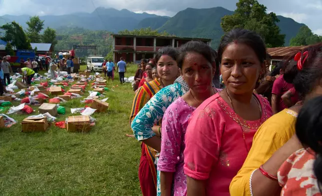 Survivors stand in a queue to receive relief supplies in the Devighat area of Nuwakot district in Nepal, Friday, Aug. 28, 2026. (AP Photo/Niranjan Shrestha)