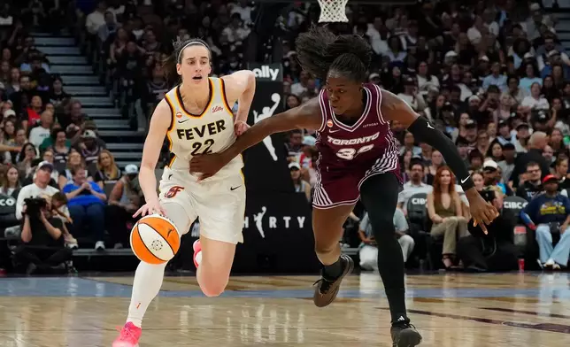 Indiana Fever's Caitlin Clark (22) drives as Toronto Tempo's Ornella Bankole (33) defends during the first half of a WNBA basketball game in Toronto on Tuesday, Aug. 18, 2026. (Chris Young/The Canadian Press via AP)