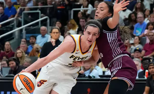 Indiana Fever's Caitlin Clark (22) drives past Toronto Tempo's Kiki Rice (1) during the first half of a WNBA basketball game in Toronto on Tuesday, Aug. 18, 2026. (Chris Young/The Canadian Press via AP)