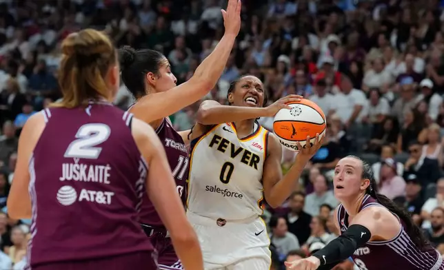 Indiana Fever's Kelsey Mitchell (0) drives as Toronto Tempo's Kia Nurse (11) and Marina Mabrey (3) defend during the first half of a WNBA basketball game in Toronto on Tuesday, Aug. 18, 2026. (Chris Young/The Canadian Press via AP)