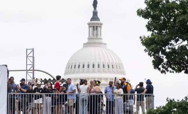 Spectators watch from an overpass near the U.S. Capitol as race car drivers take practice runs along Pennsylvania Avenue prior to Sunday's Freedom 250 Grand Prix auto race in Washington, Saturday, Aug. 22, 2026. (AP Photo/Manuel Balce Ceneta)
