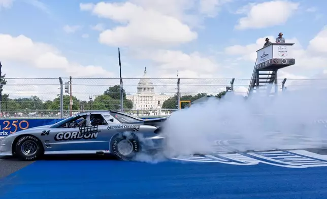 Jeff Gordon, driving an historic IROC Pontiac Firebird, performs a burnout after completing an IROC race, Saturday, Aug. 22, 2026, in Washington. (AP Photo/Manuel Balce Ceneta)
