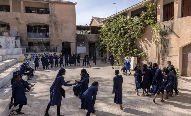 Girls play a game at the Mariama Ba School playground in Goree Island, Senegal, Thursday, March 12, 2026. (AP Photo/Caitlin Kelly)