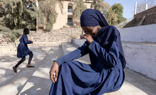 Ndeye Awa Diop sits on the steps of the Mariama Ba school in Goree Island, Senegal, Thursday, March 12, 2026. (AP Photo/Caitlin Kelly)