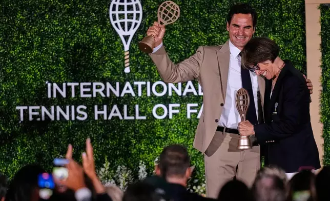 Roger Federer embraces Mary Carillo, who was honored as a broadcast contributor, during the induction ceremony at the International Tennis Hall of Fame, Saturday, Aug. 29, 2026, in Newport, R.I. (AP Photo/Charles Krupa)
