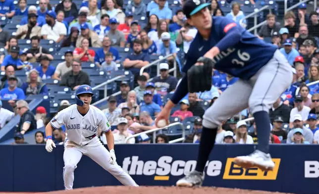 Toronto Blue Jays' Brett Bateman, left, leads off first base against Seattle Mariners starting pitcher Logan Gilbert (36) during the first inning of a baseball game in Toronto, Sunday, Aug. 30, 2026. (Jon Blacker/The Canadian Press via AP)