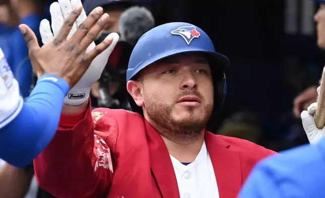 Toronto Blue Jays' Alejandro Kirk celebrates in the dugout after hitting a two-run home run against the Seattle Mariners during the first inning of a baseball game in Toronto, Sunday, Aug. 30, 2026. (Jon Blacker/The Canadian Press via AP)