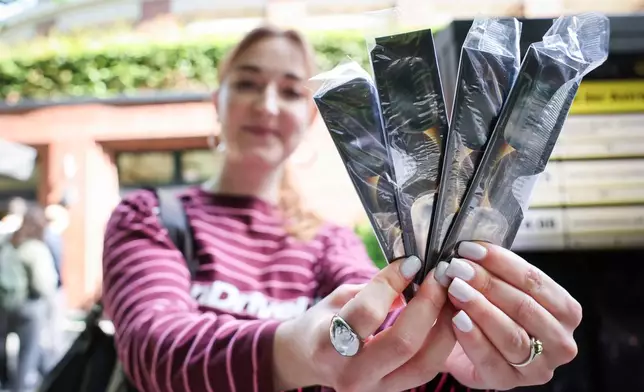 Jana Timm is holds four pairs of special solar viewing glasses that she bought at the Hamburg Planetarium to safely observe the partial solar eclipse on Wednesday, Aug. 12, 2026 in Hamburg, Germany. (Christian Charisius/dpa via AP)