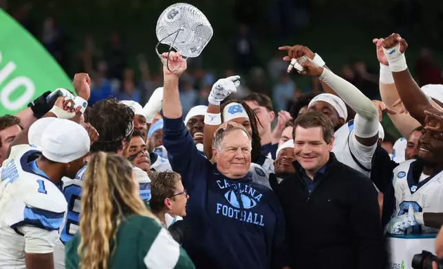 North Carolina head coach Bill Belichick, center, and his team celebrate after defeating TCU in an NCAA college football game in Dublin, Ireland, Saturday, Aug. 29, 2026. (AP Photo/Peter Morrison)