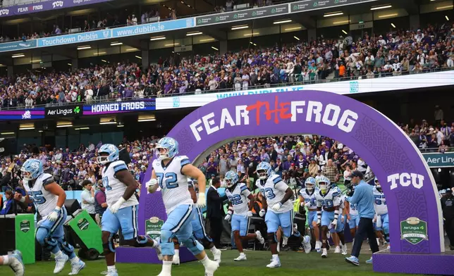 North Carolina players run onto the field before an NCAA college football game against TCU in Dublin, Ireland, Saturday, Aug. 29, 2026. (AP Photo/Peter Morrison)