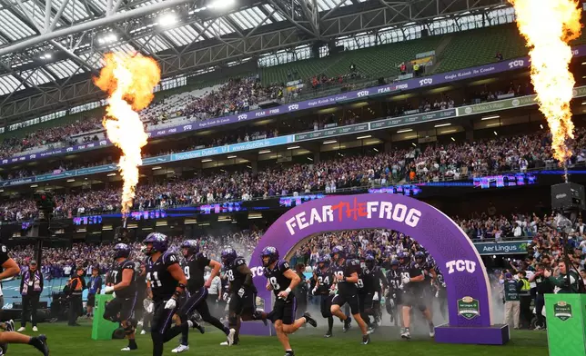 TCU players run onto the field before an NCAA college football game against North Carolina in Dublin, Ireland, Saturday, Aug. 29, 2026. (AP Photo/Peter Morrison)