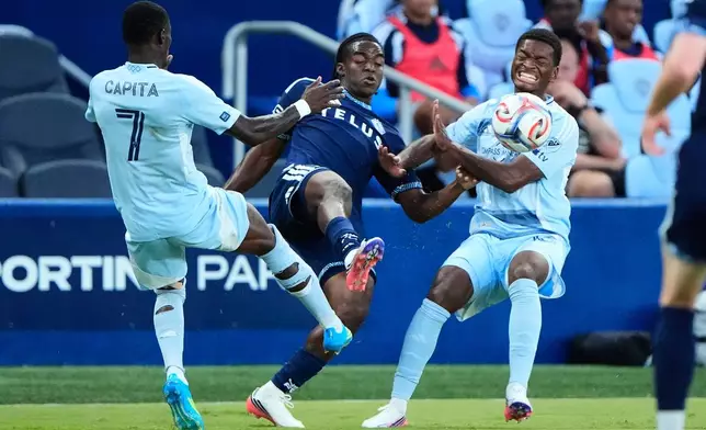 Vancouver Whitecaps' Bruno Caicedo, center, kicks the ball under pressure from Sporting Kansas City's Capita Capemba (7) and Justin Reynolds during the first half of an MLS soccer match Saturday, Aug. 29, 2026, in Kansas City, Kan. (AP Photo/Charlie Riedel)
