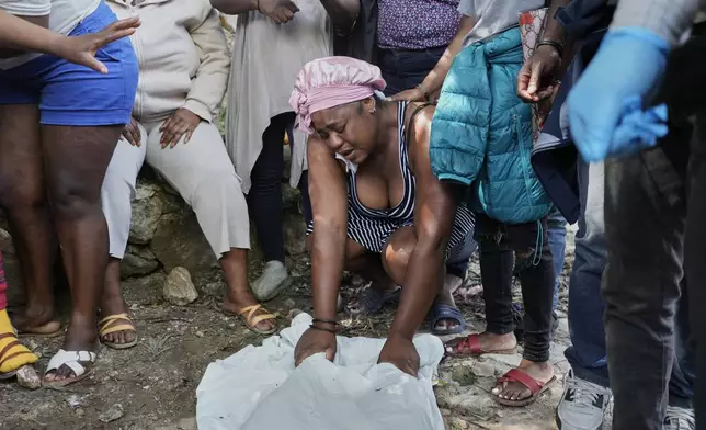 People mourn over the bodies of people they said were their relatives and killed in a gang attack in the Kenscoff neighborhood of Port-au-Prince, Haiti, Monday, Aug. 24, 2026. (AP Photo/Odelyn Joseph)