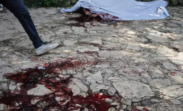 Blood stains the ground left behind by the victim of a gang attack in the Kenscoff neighborhood of Port-au-Prince, Haiti, Monday, Aug. 24, 2026. (AP Photo/Odelyn Joseph)