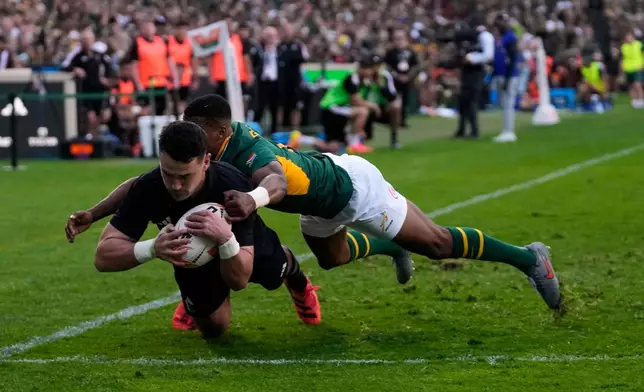 New Zealand's Will Jordan, front, scores a try as South Africa's Grant Williams tries to defend during a Test rugby match between South Africa and New Zealand, in Johannesburg, South Africa, Saturday, Aug. 22, 2026. (AP Photo/Themba Hadebe)