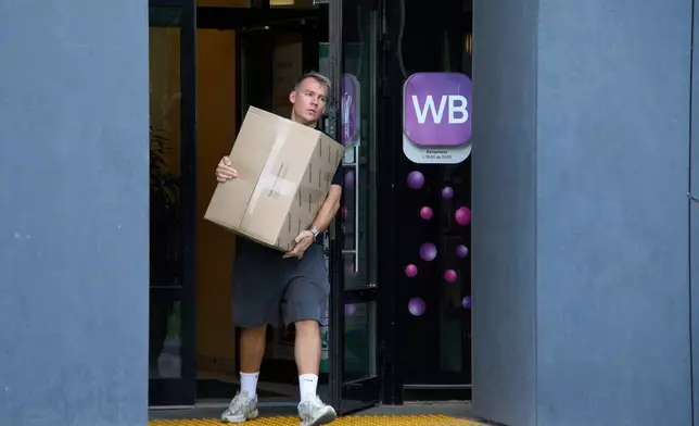 FILE - A man carrying a package leaves a pickup point for online retailer Wildberries in Moscow on Wednesday, July 22, 2026. (AP Photo/Alexander Zemlianichenko, File)