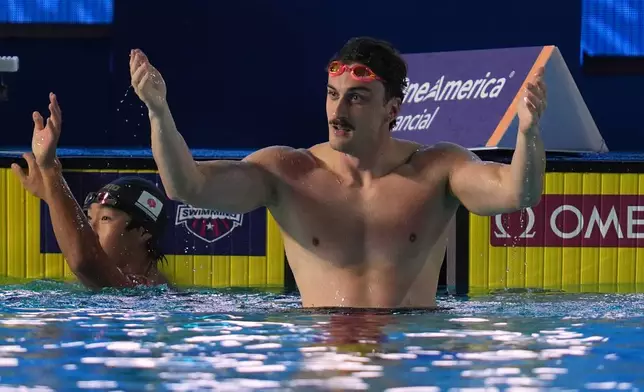 Van Mathias, of the United States, right, celebrates after winning the 100 meters breaststroke alongside silver medalist Shin Ohashi, of Japan, at the Pan Pacific Swimming Championships Thursday, Aug. 13, 2026 in Irvine, Calif. (AP Photo/Gregory Bull)