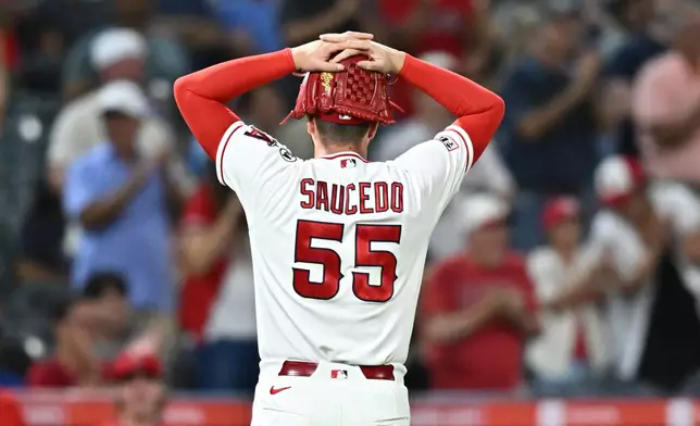 Los Angeles Angels pitcher Tayler Saucedo reacts while walking back to the dugout after a catch by right fielder Wade Meckler during the seventh inning of a baseball game against the Texas Rangers, Monday, Aug. 10, 2026, in Anaheim, Calif. (AP Photo/William Liang)