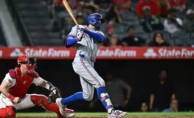 Texas Rangers' Brandon Nimmo, right, hits an RBI single during the 10th inning of a baseball game against the Los Angeles Angels, Monday, Aug. 10, 2026, in Anaheim, Calif. (AP Photo/William Liang)