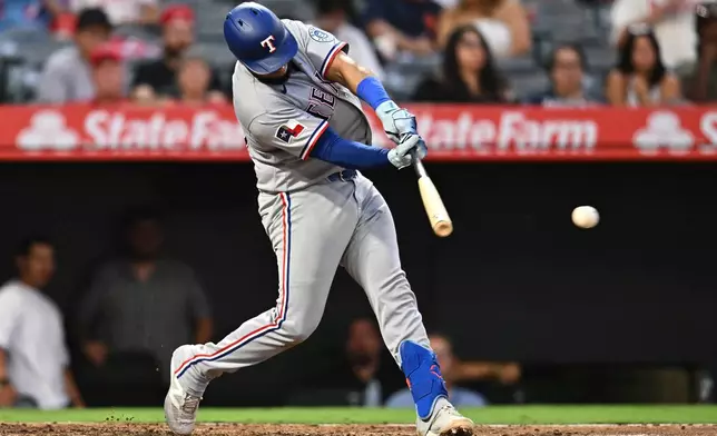 Texas Rangers' Elias Díaz hits an RBI single during the fourth inning of a baseball game against the Los Angeles Angels, Monday, Aug. 10, 2026, in Anaheim, Calif. (AP Photo/William Liang)