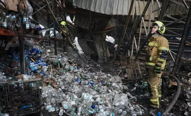 Firefighters work at the site of a fire after Russian missiles hit a food warehouse near Kyiv, Ukraine, Wednesday, Aug. 5, 2026. (AP Photo/Efrem Lukatsky)