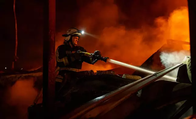 Firefighters put out a fire after Russian missiles hit a warehouse in Kyiv, Ukraine, Wednesday, Aug. 5, 2026. (AP Photo/Dan Bashakov)