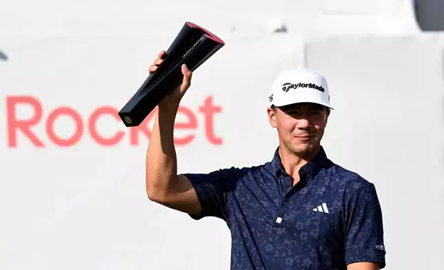 Michael Thorbjornsen hoists the trophy after winning the Rocket Classic golf tournament, Sunday, Aug. 2, 2026, in Detroit. (AP Photo/Jose Juarez)