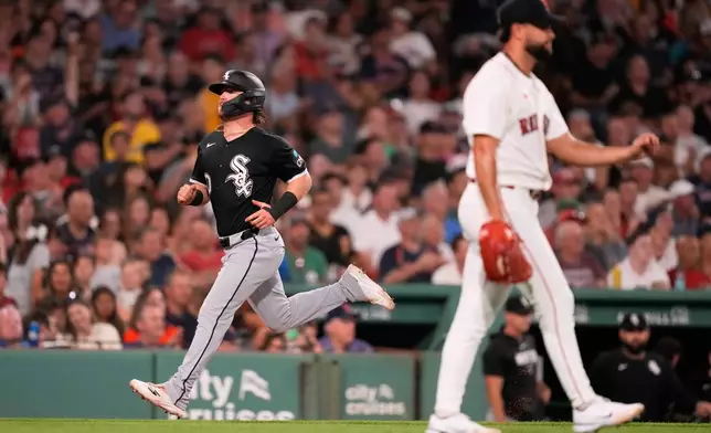 Chicago White Sox's Chase Meidroth, left, scores on a sacrifice by Miguel Vargas during the fifth inning of a baseball game against the Boston Red Sox, Tuesday, Aug. 4, 2026, in Boston. (AP Photo/Charles Krupa)
